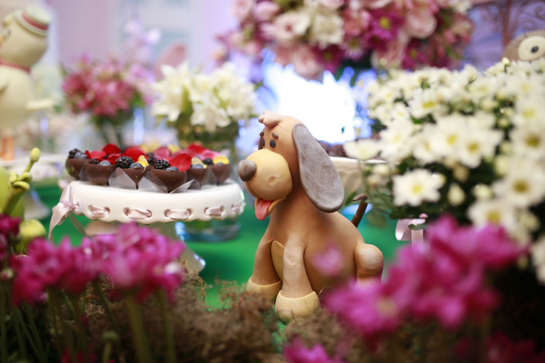 Colorful floral decoration with a cute dog figure and sweets, perfect for celebrations.